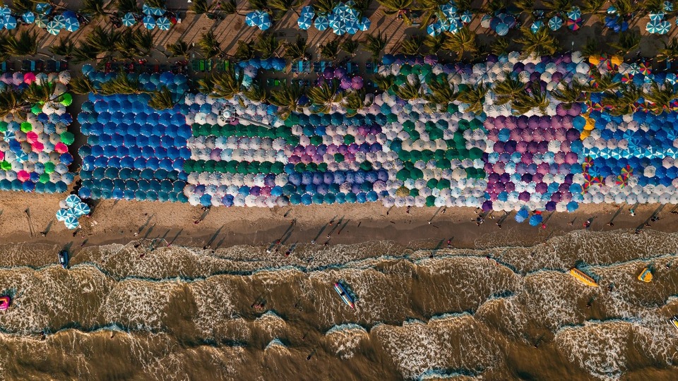 ภาพมุมสูงของชายหาดที่มีร่มหลากสีสัน รับถ่ายวีดีโอ พัทยา เหมาะสำหรับ ถ่ายวีดีโอท่องเที่ยว ทำวีดีโอ รับทำวีดีโอ รับถ่ายโดรน ตัดต่อวิดีโอท่องเที่ยว วีดีโอโปรโมทสินค้า ถ่ายวีดีโอ ชลบุรี ตัดต่อวีดีโอ